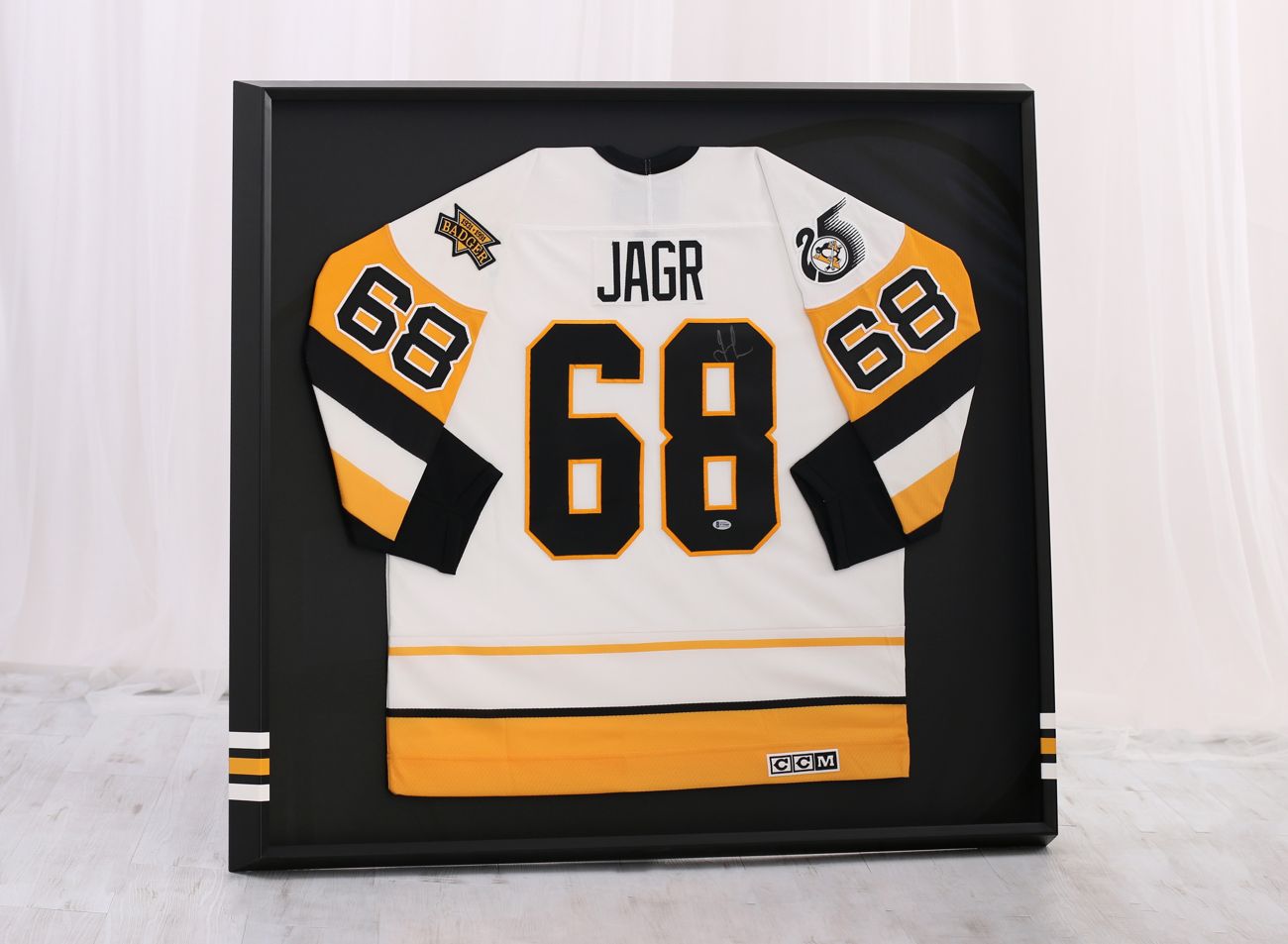 Hokejový dres Pittsburg  Jaromír Jágr zarámovaný v  černém rámu s týmovými barvami | © Rámařství Frame it