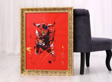 Výrazně barevná dynamická malba černého býka na červeném podkladě je zarámovaná v zakázkovém zlaceném rámu s modelovým dokončením uzavřených roků, vzorem akantu a černou olejovou patinou.