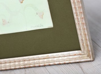 Dětská ilustrace Žabáček Jana Kudláčka je zapaspartovaná v zelených muzeálních materiálech a v zakázkvém rámu