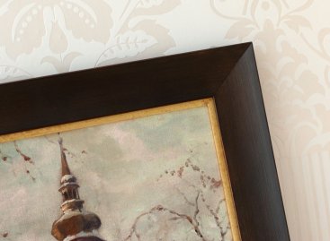 Moderní hnědý rám je doplněný o zlatou filetu aby ladil s obrazem pražské Lorety