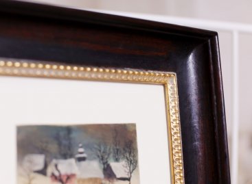 Obraz Krajina Jiřího Trnky je položen na bavlněné muzeální paspartě a má hnědo-zlatý zakázkový rám