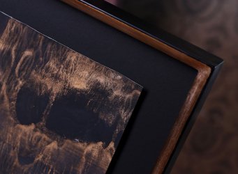 Floating mount s černou paspartou a zakázkovým rámem ve zlato-černém provedení pro obraz hor Patrika Hábla na papíře při pohledu zblízka na pravý horní roh obrazu.