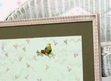 Detail rámování ilutrace Žabáček jana Kudláčka s pohledem na stříbrný luxusní rám