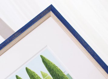 Detail rámování obrazu Tomáše Bíma Moet s modrým dřevěným patinovaným rámem a bílou paspartou