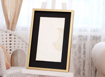 Prostorové rámování reliéfního tisku Sblížení Olbrama Zoubka do zlatého rámu a černé pasparty