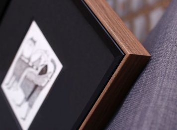 Zdánlivě zcela černý rám obrazu Adolfa Borna Učitel národů má zjemňující hnědý bok připomínající přírodní dřevo