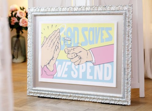 Pasta Oner God Saves levituje v modrém ornamentálním ráu nad stříbrnou paspartou 