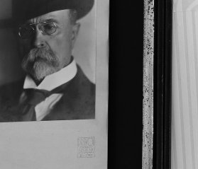 Černobílý detail zarámování historické fotografie s portrétem prezidenta TGM do patinovaného dřevěného rámu, speciální muzeální pasparty a muzeálního skla.