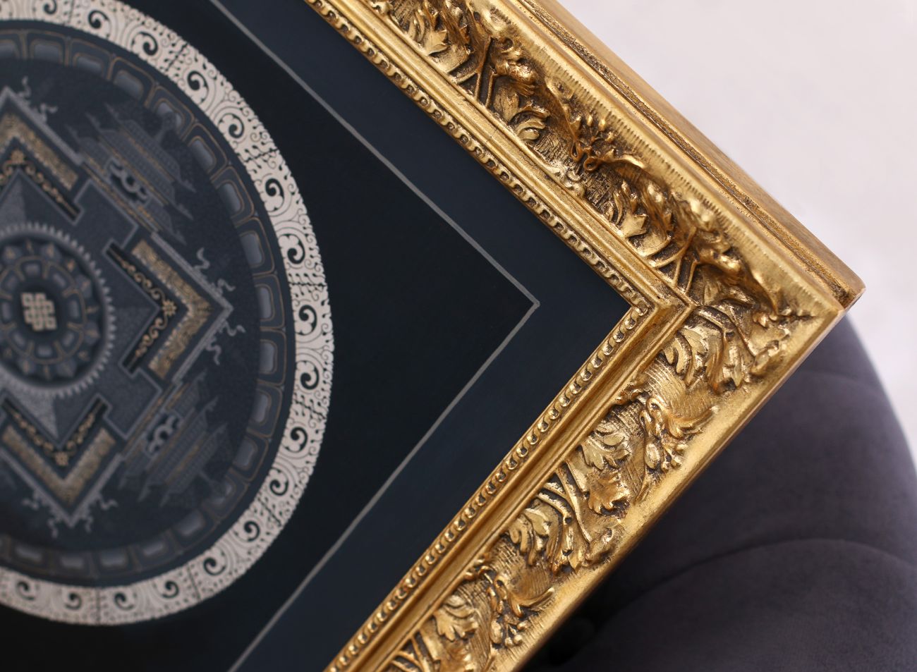 detail zlatého vyřezávaného rámu Aštamangala mandaly