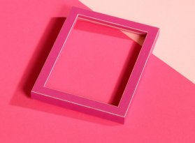 Úzký hranolovitý rámeček ze dřeva v růžové barvě a probroušenými hranami položený dvou odstínech růžových paspart