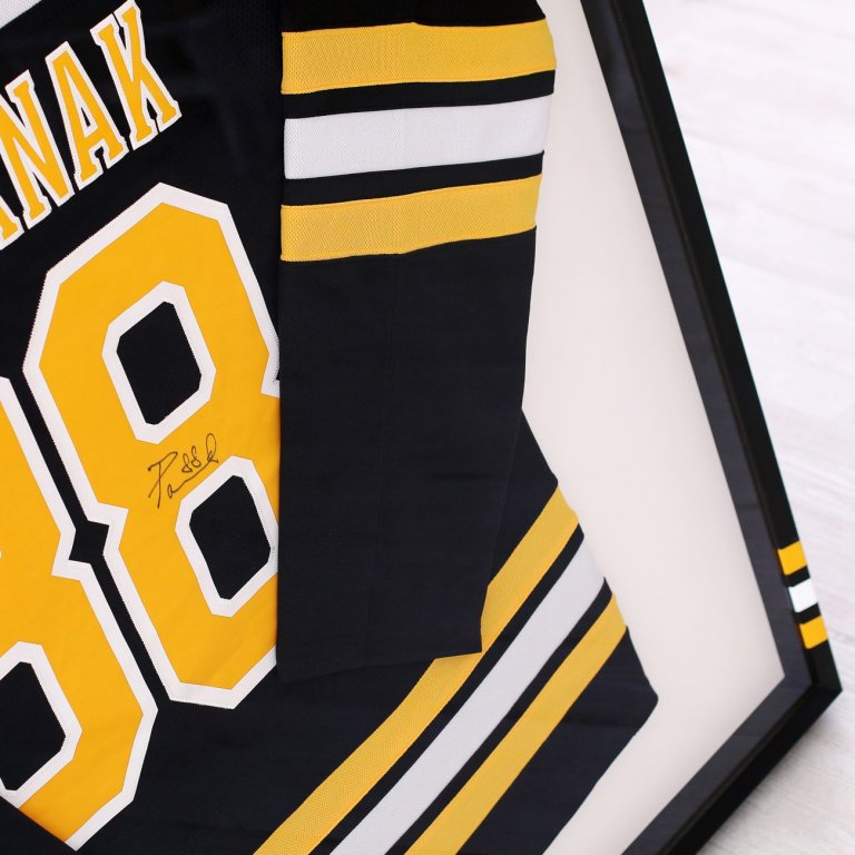 Podepsaný hokejový dres Bruins Radek Pastrňák zarámovaný v  černém rámu s týmovými barvami