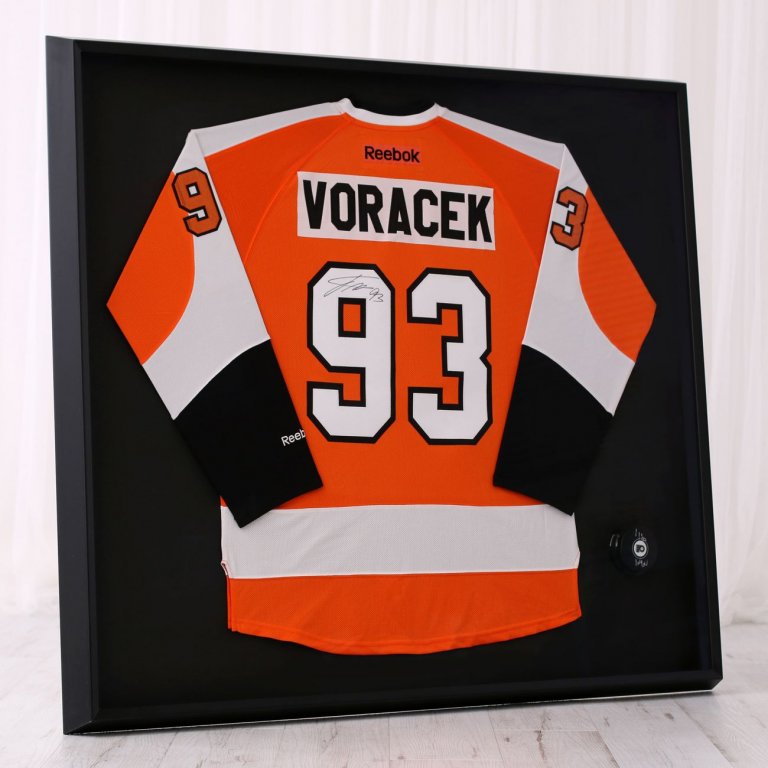 Hokejový NHL dres Jakuba Voráčka z Philadelphia Flyers zarámovaný v moderním černém rámu s černou paspartou a podepsaným hraným pukem v muzejním provedení.