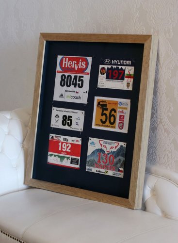 Rámování běžeckých startovních čísel do přírodního borovicového rámu a tmavé pasparty