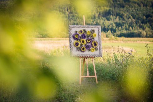 Rámování květinového obrazu z umělých látkových květin do krásného ornamentálního rámu 
