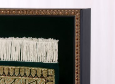 Hluboký vitrínový rám na perský koberec má černý bok a jemný zlacený ornament