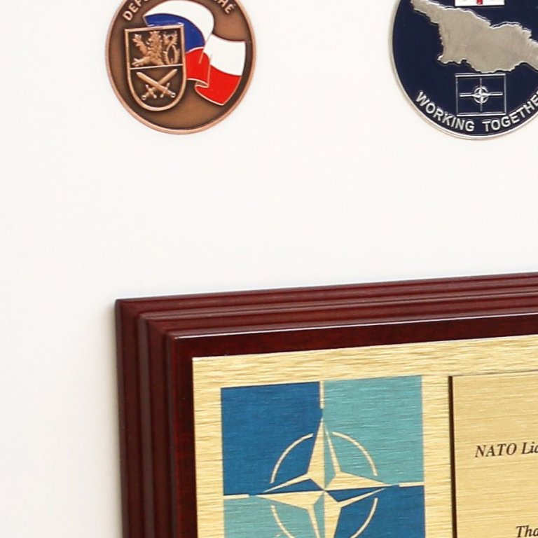 Vojenské medaile NATO jsou v rámu zapuštěny, aby držely na místě bez lepení