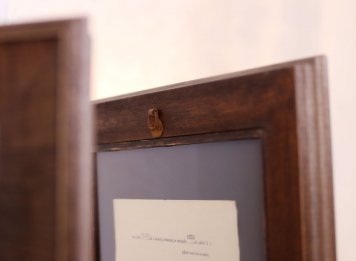 Zadní strana oboustranného rámování historické smlouvy mezi dvě skla a dvě pasparty
