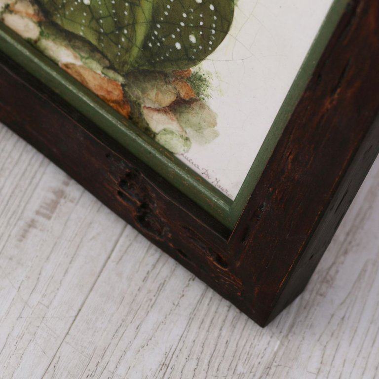 Zelená fileta hnědý dřevěný rám barevně doplňuje a rozšiřuje, aby pojal nepravidelné okraje kachličky 