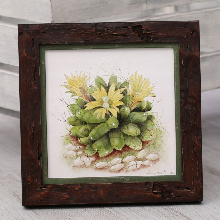 Kachle s malbou kaktusu zarámovaná v hnědém dřevěném rámu doplněném o zelenou filetu