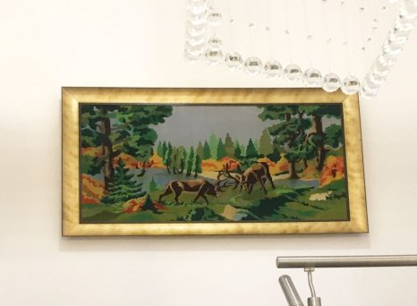 Klasická výšivka vypnutá jako plátno ve zlatém rámu bez skla v interiéru