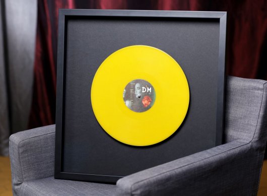Černý muzeální rám na vinyl Depeche Mode s gramofonovou deskou bez obalu ukotvenou na zakázkově vyrobené ocelové osičce.