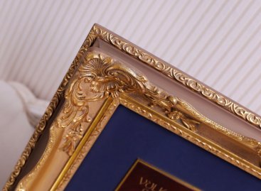 Jemně vypracovaný rohový ornament a profil blondelového rámu s LP deskou při detailním pohledu 