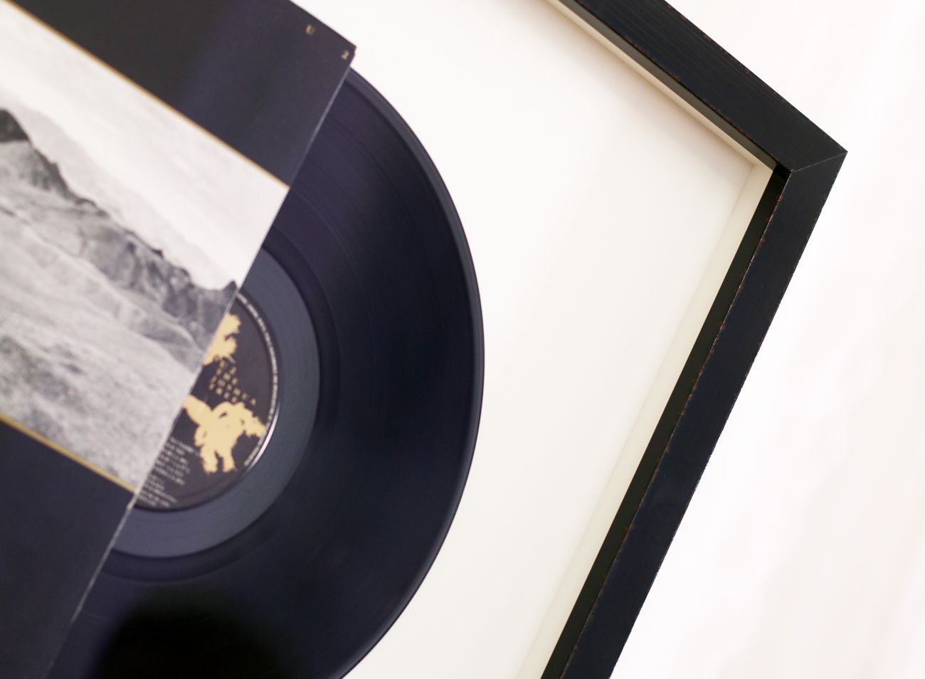 Gramofonová deska U2 je zárámovaná částečně zasunutá v obalu | © Rámařství Frame it.cz