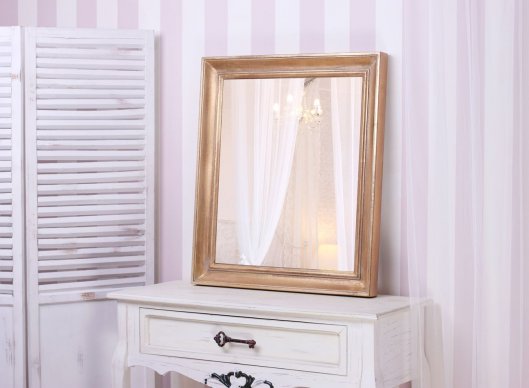 Tradiční zrcadlo v dřevěném zlaceném rámu v elegantním interiéru