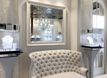 Interiér klenotnictví Alo Boutique v obchodním domě Palladium v Praze s bílo stříbrným italským rámem elegantního nástěnného zrcadla.