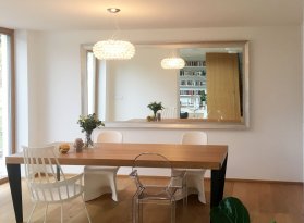 XXL velké zrcadlo ve stříbrném rámu na zdi obytné jídelny moderního bytu v Praze