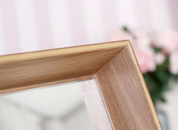 Zrcadlo s kulatou matně broušenou hranou v nezvykle hlubokém rámu z masivního dubu se zlacenou hranou vystupující výrazně před zrcadlovinu.