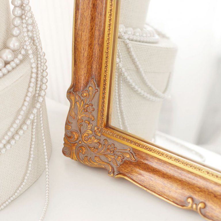 Elegantní kosmetické zrcadlo v luxusním blondelovém rámu oříškové barvy v interiéru dámského boudoire