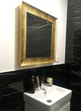 Designová černo-bílá koupelna v luxusní pražské čtvrti s čtvercovým zrcadlem s moderním lesklým zlatým rámem Salvadori a s broušenou fazetou.