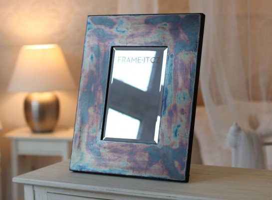 Luxusní malé zrcadlo s neobvyklým opalizujícím povrchem v interiéru v Praze s vypískovaným nápisem Frame-it.cz