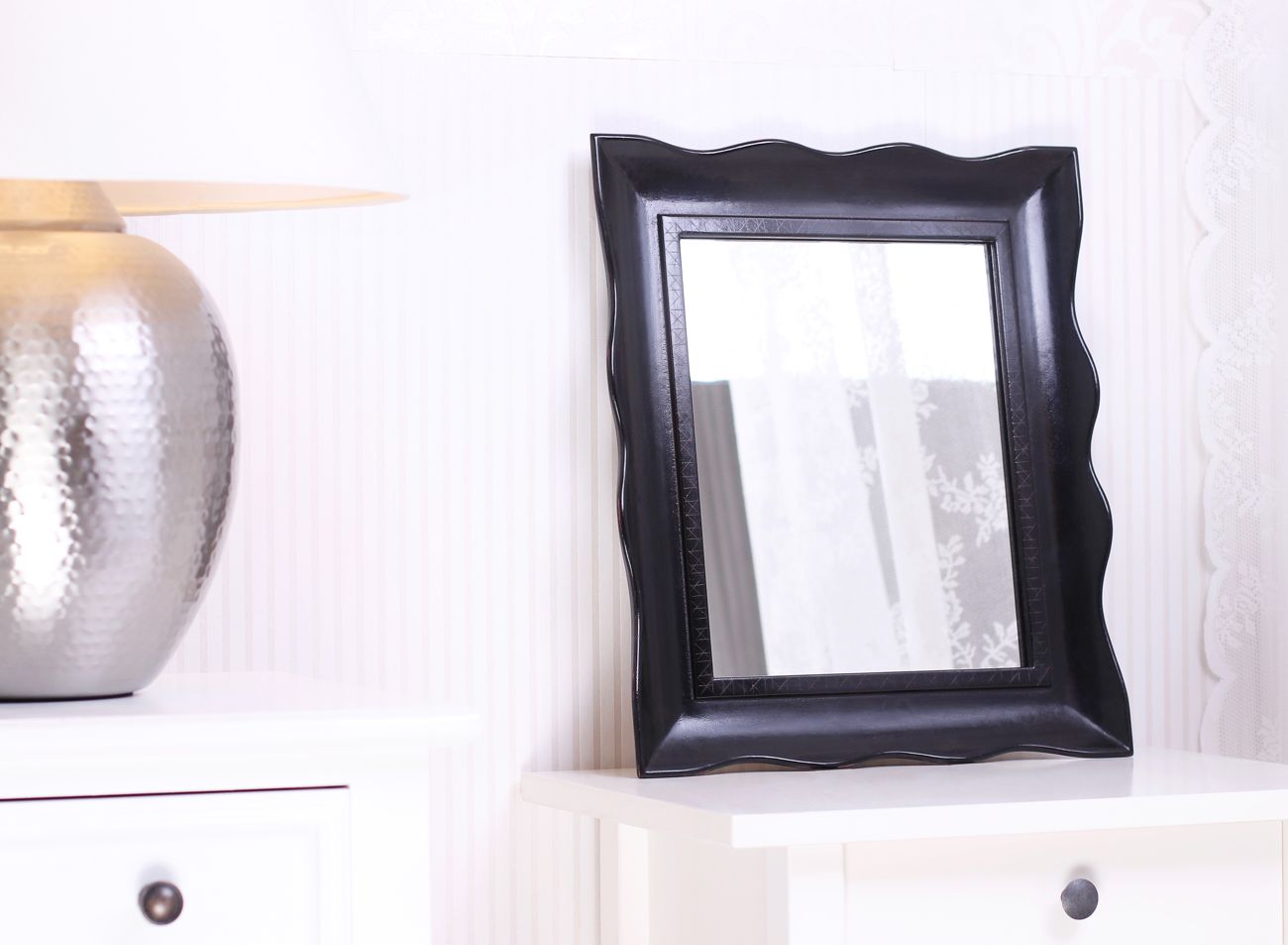 Malé zrcadlo v luxusním černém vyřezávaném rámu v interiéru | © Frame-it.cz