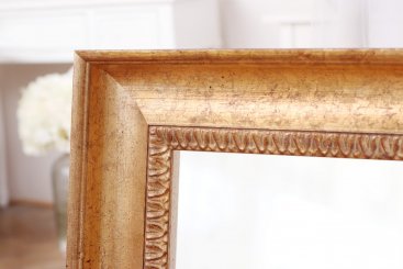 Elegantní ornament na zlatém rámu zrcadla do předsíně