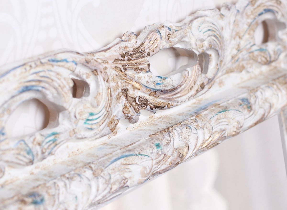 Široký prořezávaný rám v bílé barvě má zlaté, modré a hnědé deatily a patinu | © Frameit.cz